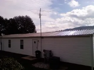 New metal roof on a single wide mobile home with a TV antenna in Timmonsville