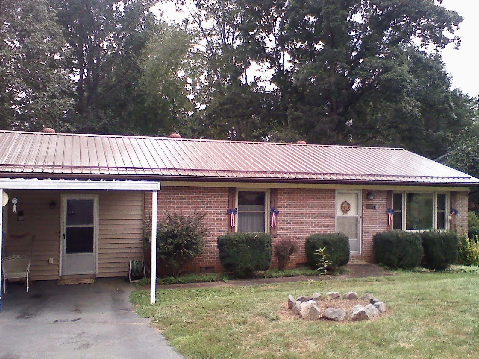 Bronze metal roof and carport on a brick ranch home — Roof Repair work by our crew in Timmonsville